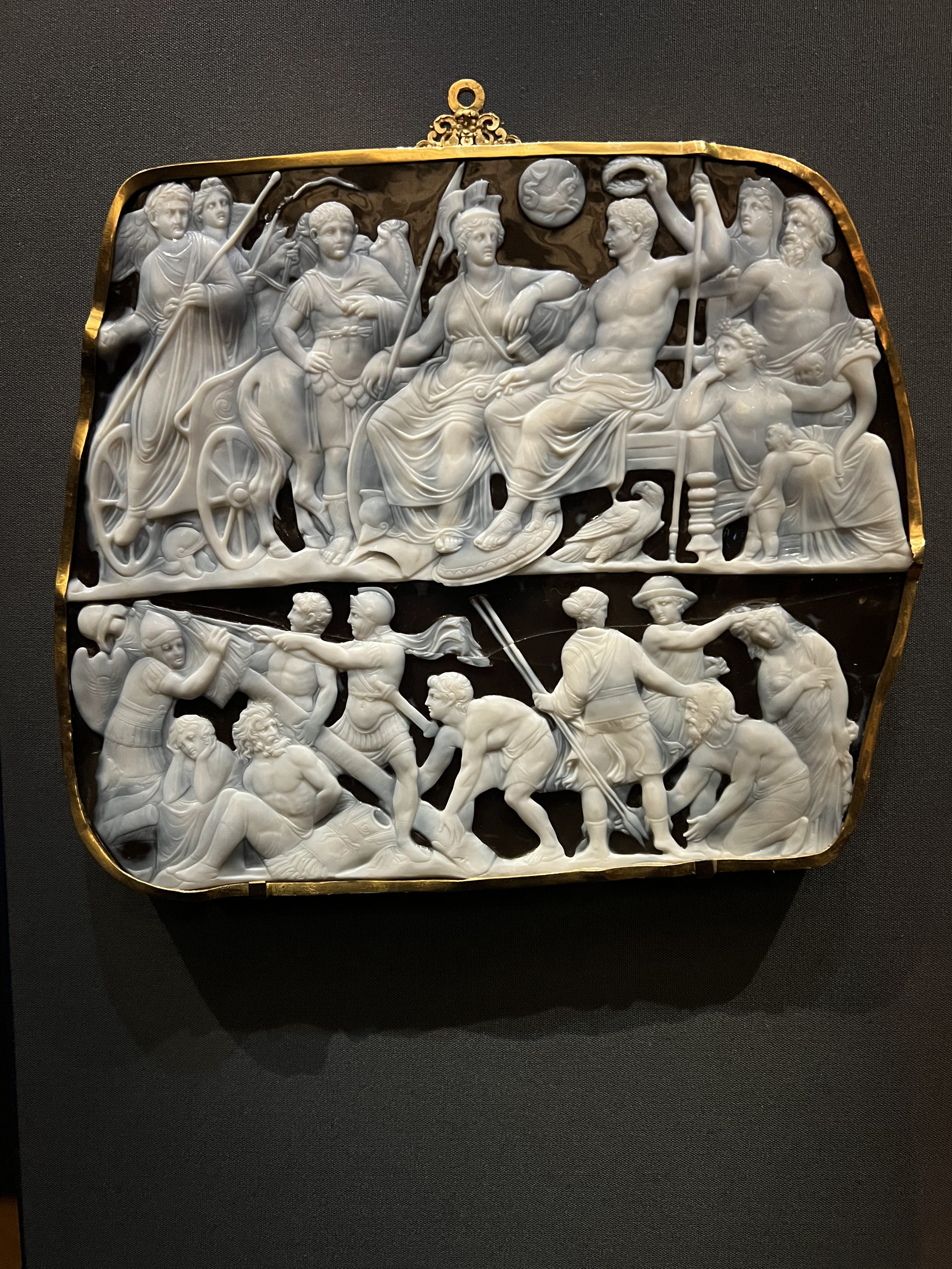 A cameo gem with white characters on a dark onyx background.