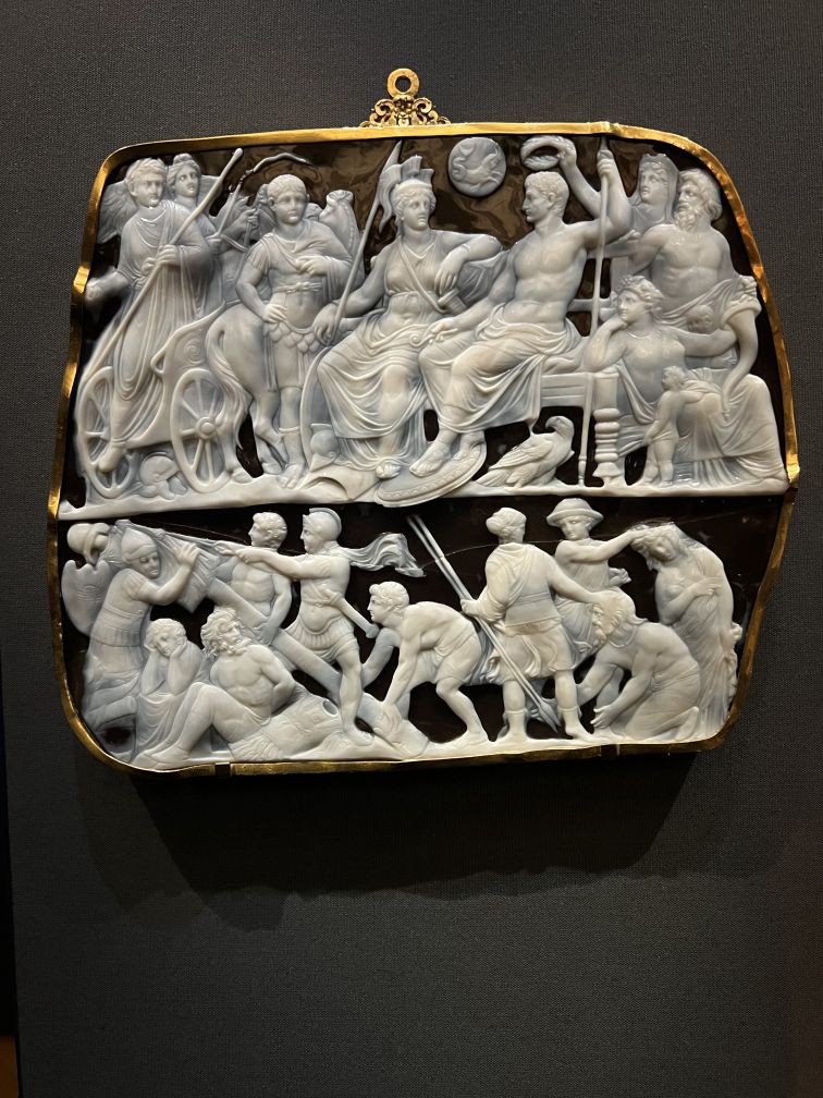 A cameo gem with white characters on a dark onyx background.