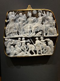 A cameo gem with white characters on a dark onyx background.